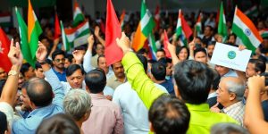 Oamenii participând la un miting politic vibrant.